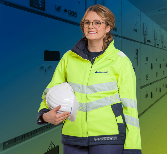 eine frau in arbeitskleidung steht vor einem grünen hintergrund